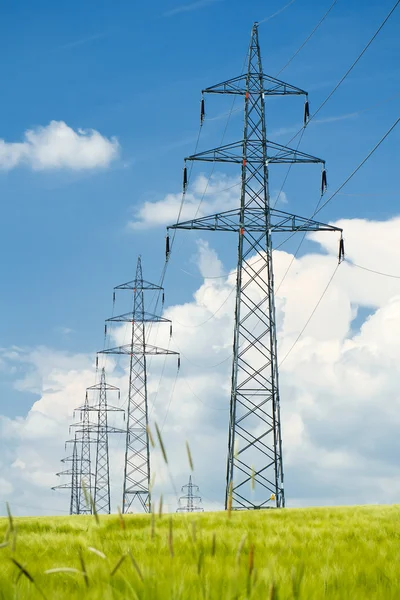 Высокое напряжение линий электропередач против голубого неба — стоковое фото