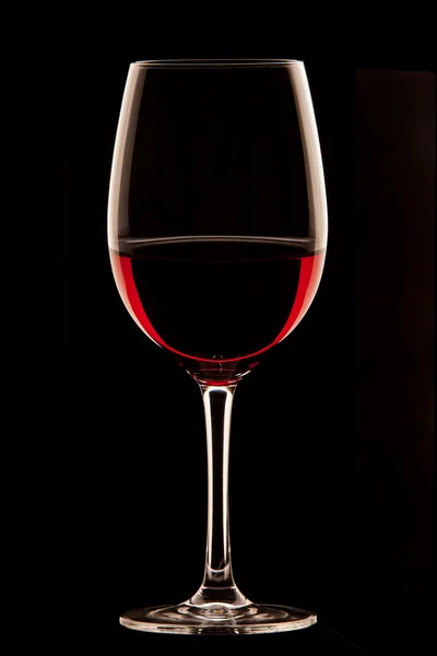 Glas rött vin på svart bakgrund. — Stockfoto