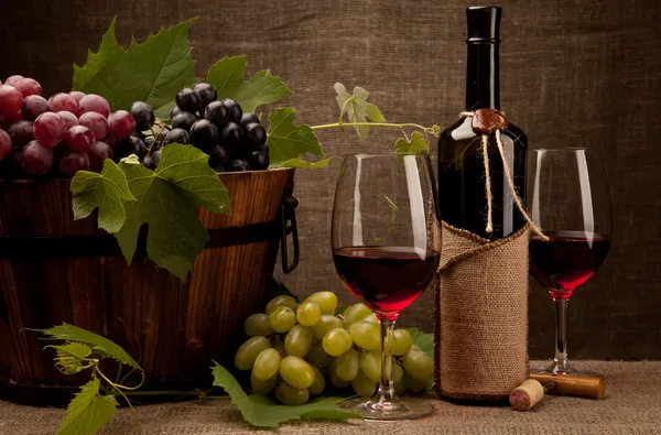 Natura morta con bottiglie di vino, bicchieri e uva — Foto Stock