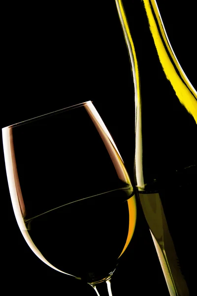 Bakgrundsbelyst detalj av ett glas vin och vin flaskan — Stockfoto