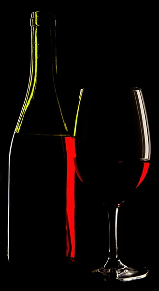 Abstract view of a glass wine and the wine bottle against a soli — Stock Photo, Image