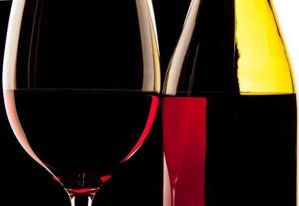 Bakgrundsbelyst detalj av ett glas vin och vin flaskan mot en sol — Stockfoto