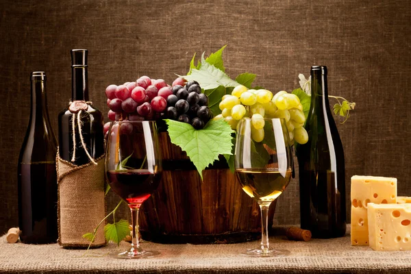 Натюрморт з пляшками вина, келихами та виноградом — стокове фото