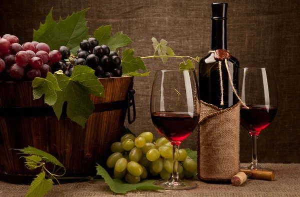 Stillleben mit Weinflaschen, Gläsern und Trauben Stockbild