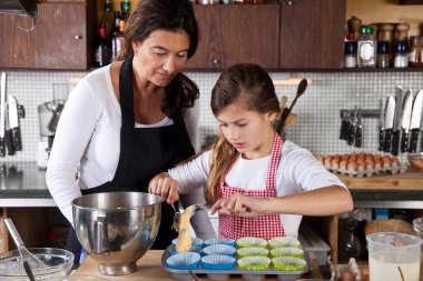 Mother and daughter baking at home clipart