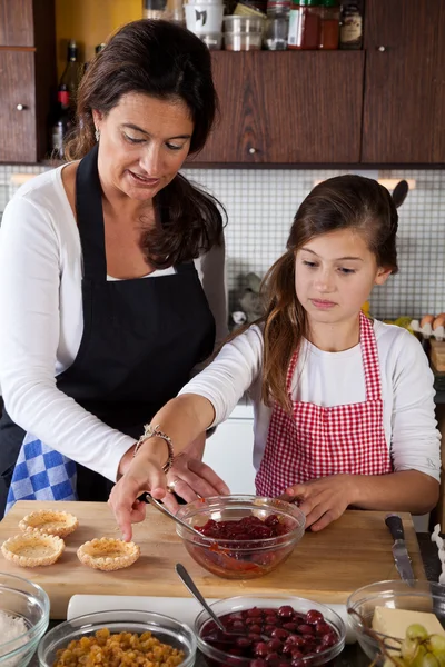 母亲和女儿在家里烤 — Stockfoto