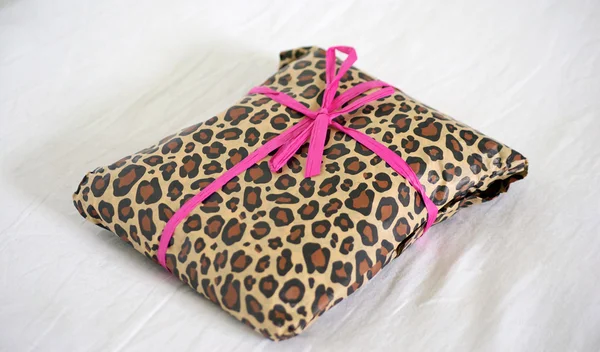 Stock image Present wrapped in leopard print with pink ribbon