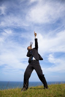 Businessman stand on the hill and holding megaphone with cloud background clipart