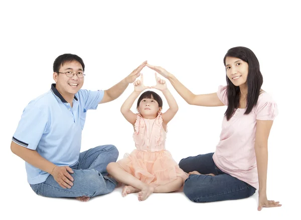 Glückliche junge Familie zeigt Hauszeichen an der Hand — Stockfoto