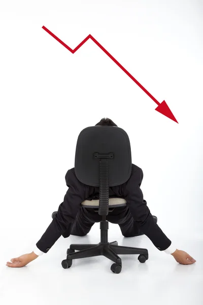 Бізнесмен лежить на стільці і дивиться червоний графік вниз — стокове фото