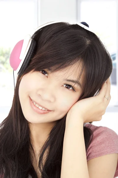 微笑着听音乐的亚洲年轻女孩 — 图库照片