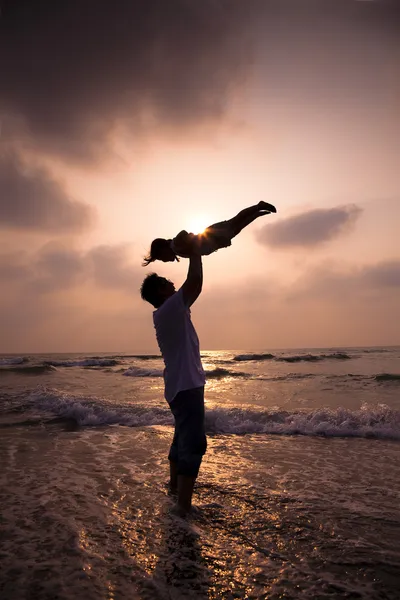 Het silhouet van gelukkige familie op het strand — Stockfoto