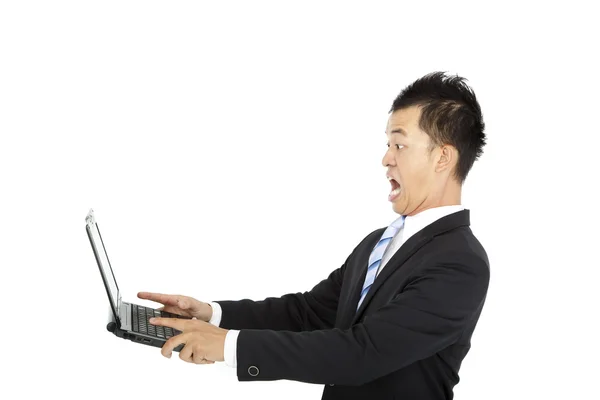 Sorprendido joven empresario viendo y sosteniendo el ordenador portátil — Foto de Stock