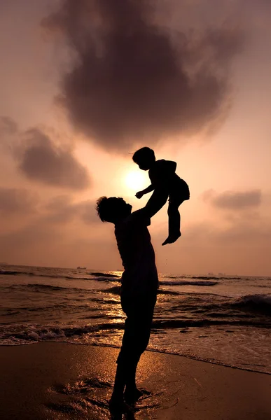 Силуэт счастливого отца и маленькой девочки на пляже — стоковое фото