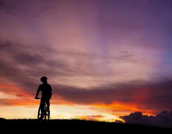 Het silhouet van de berg fiets rider op de heuvel met prachtige zonsopgang — Stockfoto