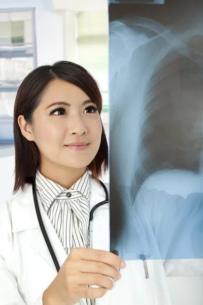 Азиатский врач просматривает рентгеновские снимки в кабинете врача — стоковое фото