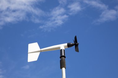 Wind wheel or anemometer with cloud background clipart