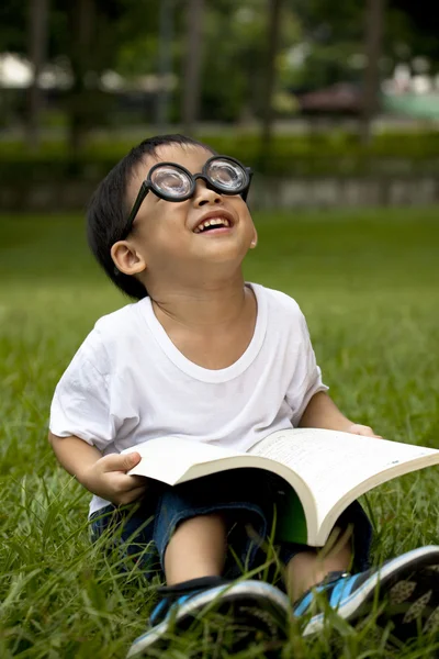 Felice asiatico ragazzo studio su il verde erba — Foto Stock