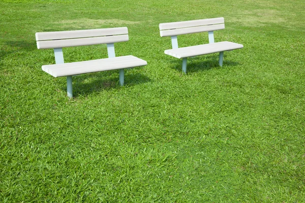 Cadeira no parque e campo verde — Fotografia de Stock