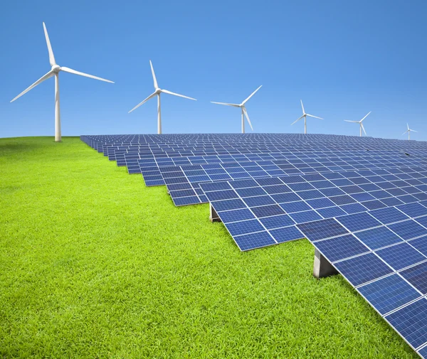 Güneş panelleri ve rüzgar türbinleri çim sahada — Stok fotoğraf