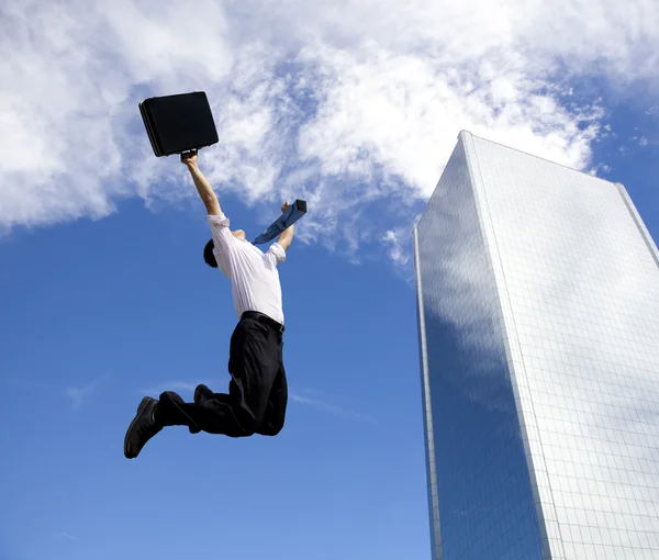 Счастливый бизнесмен прыгает перед зданием — стоковое фото