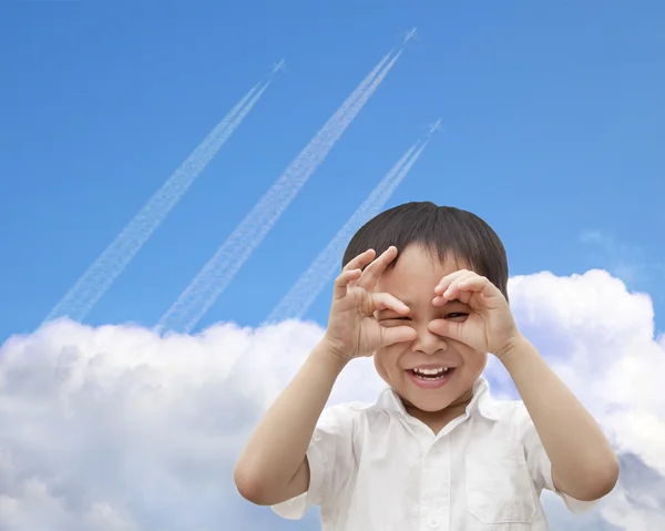 Szczęśliwy chłopiec obserwując samolot przelatuje nieba przez chmury — Zdjęcie stockowe