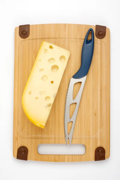 Сыр и нож на деревянной доске — стоковое фото