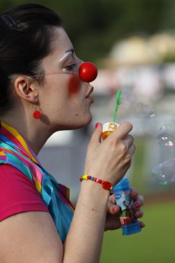 Clown girl blowing soap bubbles