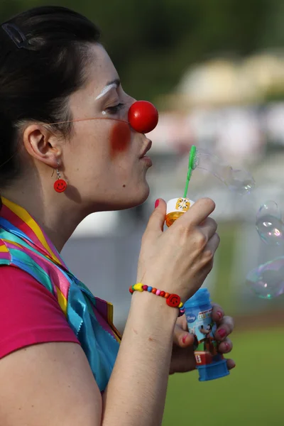 stock image Clown girl blowing soap bubbles