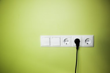 Electrical wall outlet / on green background clipart