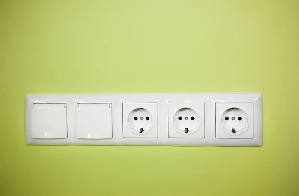 Electrical wall outlet / on green background — Stock Photo, Image