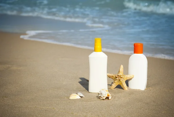 Suntan Lotion Flacons na praia com espaço de cópia — Fotografia de Stock