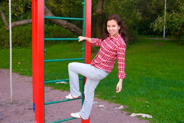 Glückliche junge Frau auf Spielplatz — Stockfoto