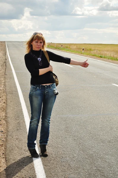 女性ヒッチハイク、道路の旅 ロイヤリティフリーのストック画像