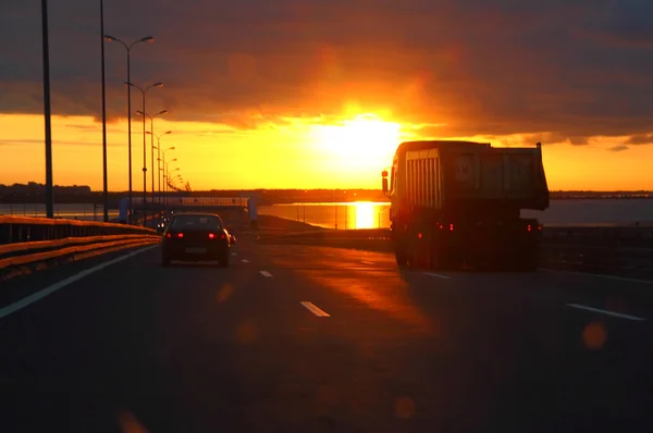 Autot auringonlaskun valtatiellä — kuvapankkivalokuva