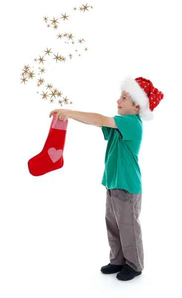 Радостный ребенок освобождает звезды от рождественского чулка — стоковое фото