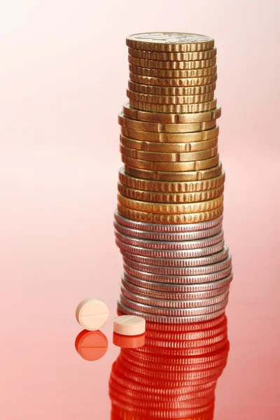 Pillole standig accanto mucchio di monete — Foto Stock