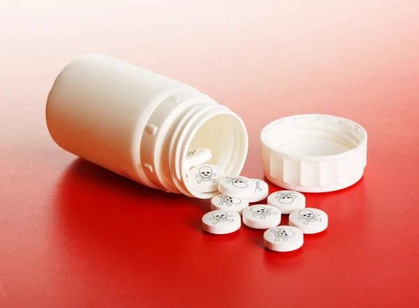 Dodelijke pillen gemorst uit kunststof container — Stockfoto
