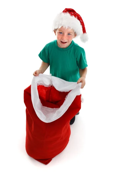 Счастливый маленький мальчик с открытым мешком Санты — стоковое фото