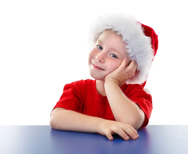 Χαριτωμένο Χριστούγεννα αγόρι κάθεται σε τραπέζι — Φωτογραφία Αρχείου