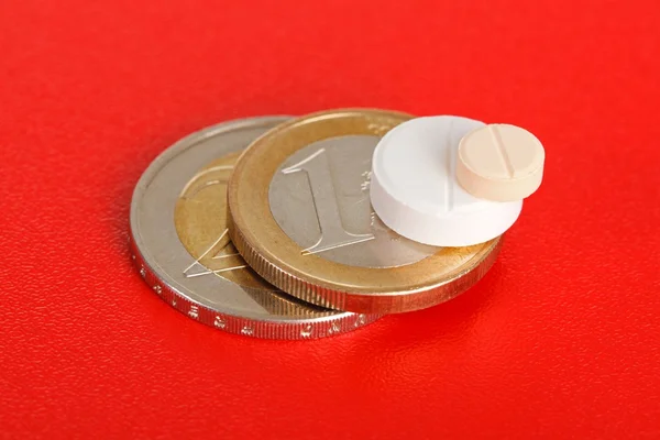Macro de dos pastillas encima de monedas de euro —  Fotos de Stock
