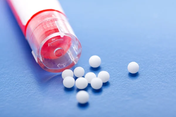 Pílulas homeopáticas modernas e recipiente — Fotografia de Stock