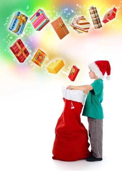 Kleiner Junge öffnet Weihnachtsmann-Tasche mit wunderbaren Geschenken — Stockfoto