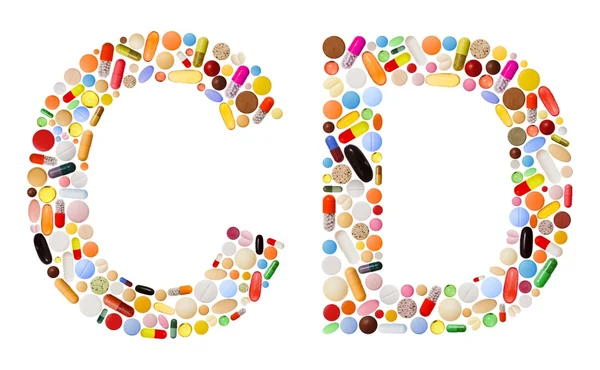 Znaky c a d z barevných pilulek — Stock fotografie