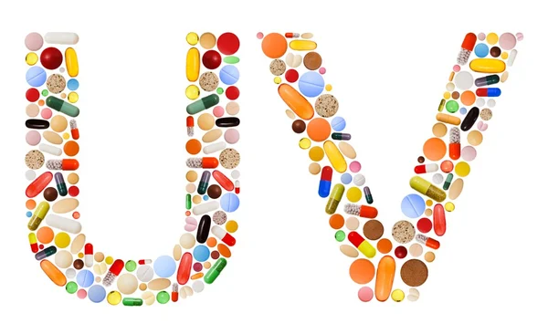 Znaků a v vyrobené z barevných pilulek — Stock fotografie