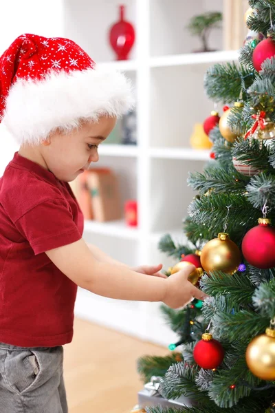 Маленький мальчик украшает елку — стоковое фото