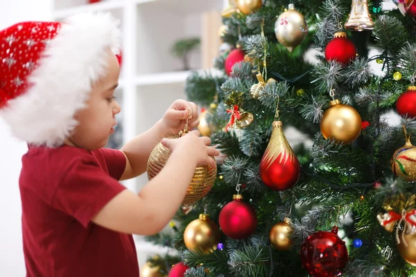 Маленький мальчик украшает елку — стоковое фото