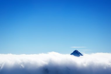 Mountain's top over clouds clipart