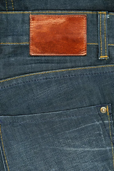 Коричнева шкіра галантерейна етикетки на темні джинсового — стокове фото