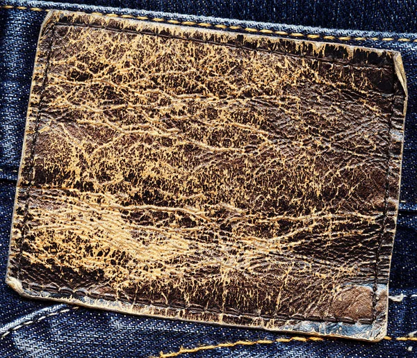 Prázdné výstřední hnědá kůže štítek na modré džínové — Stock fotografie